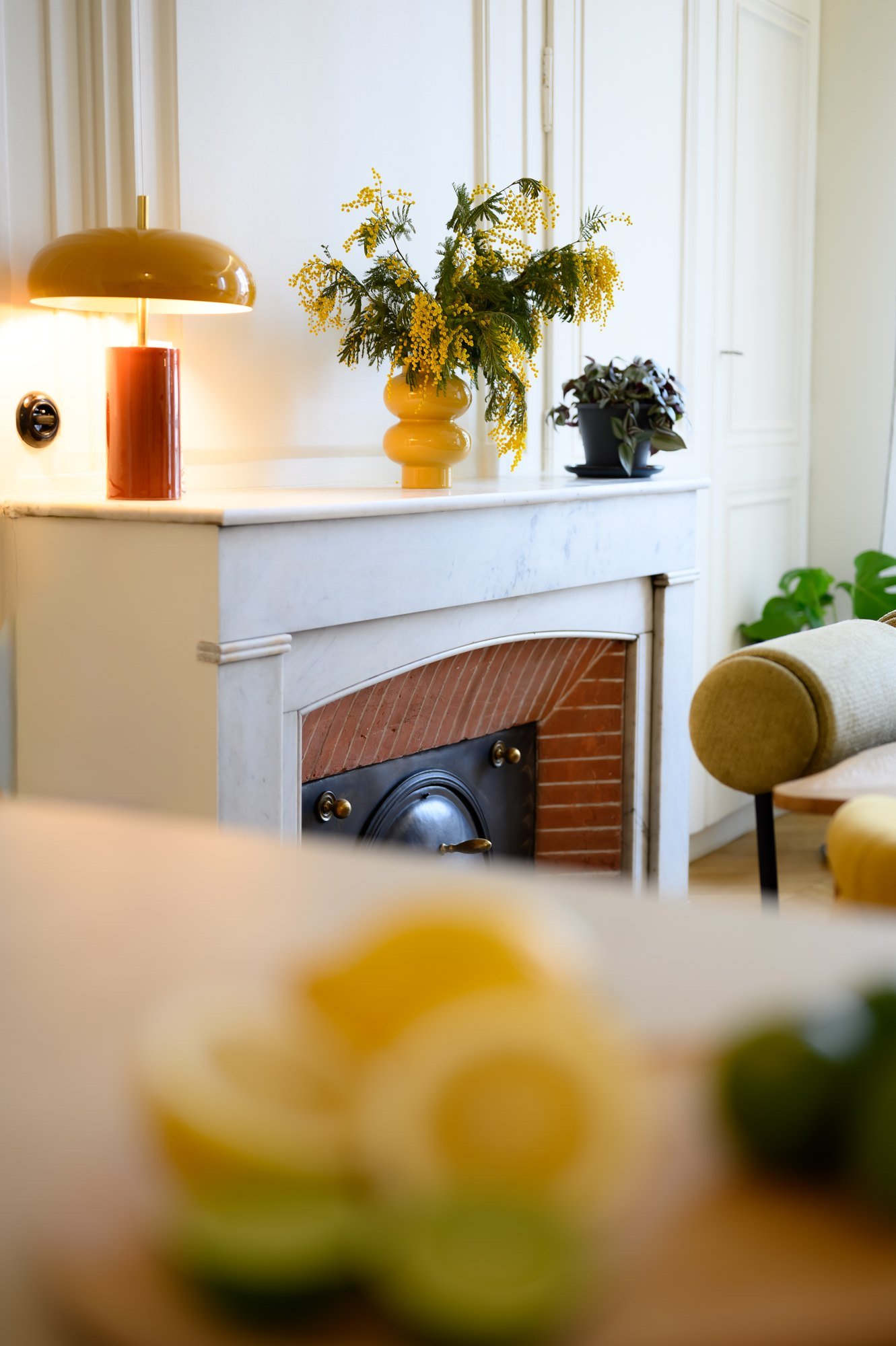 Cheminée de marbre, mimosa et lampe ambrée, appartement Ampère